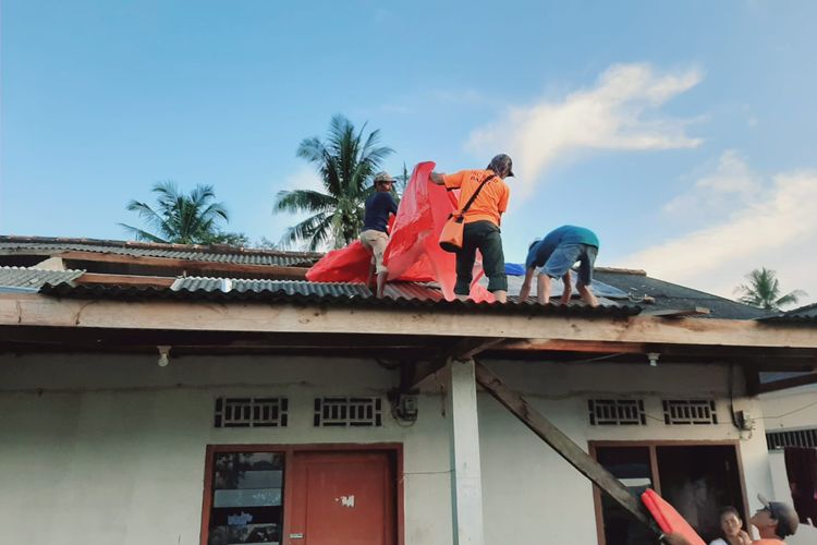 Petugas memasang terpal di rumah warga terkena puting beliung di Desa Kebintik, Bangka Tengah, Selasa (29/3/2022)