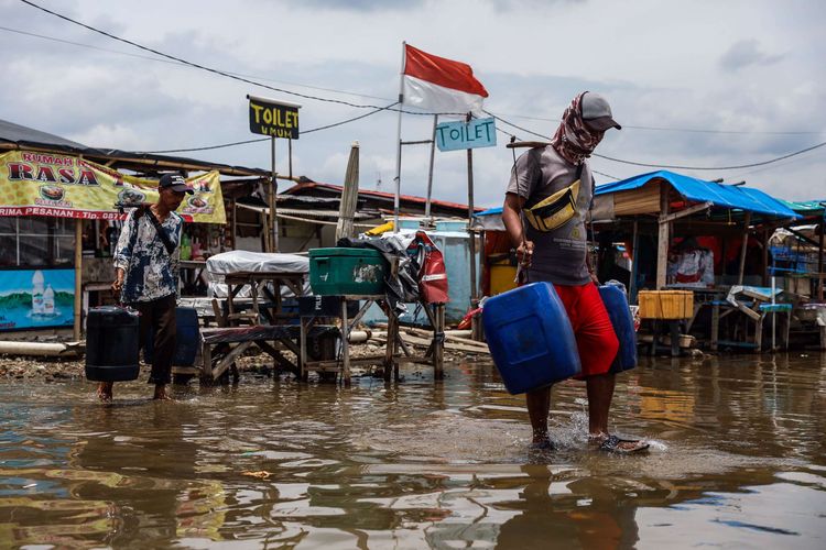 Warga beraktivitas saat banjir rob menggenangi kawasan dermaga Pelabuhan Kaliadem, Muara Angke, Jakarta Utara, kamis (22/10/2020). Banjir di kawasan tersebut sudah berlangsung lima hari. Menurut para pedagang di sekitar dermaga, banjir rob kali ini merupakan banjir yang paling parah dibanding tahun sebelumnya.