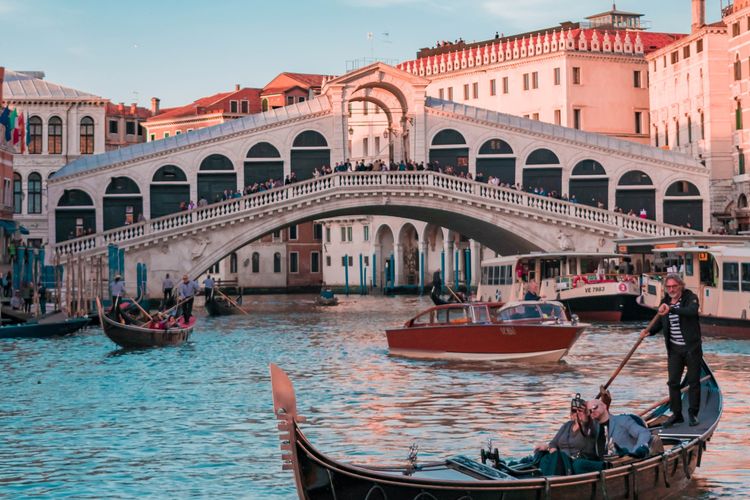 Wisatawan melewati jembatan Rialto di Venesia, Italia.