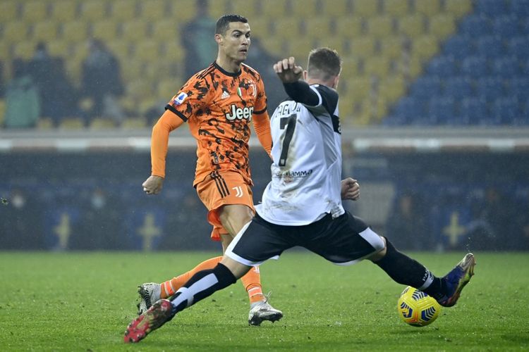 Cristiano Ronaldo mencoba melewati adangan Riccardo Gagliolo dalam laga Parma vs Juventus pada pekan ke-13 Serie A Liga Italia 2020-2021 yang digelar di Stadion Ennio Tardini, Sabtu (19/12/2020) malam waktu setempat. (Photo by Alberto PIZZOLI / AFP)