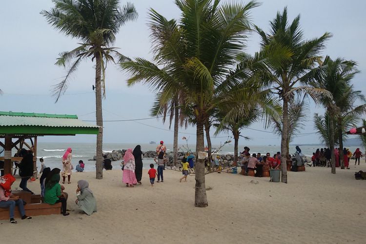 Pengunjung Pantai Batu Bedaun dengan pemandangan laut lepas bisa melihat kapal keruk timah dari lepas pantai.