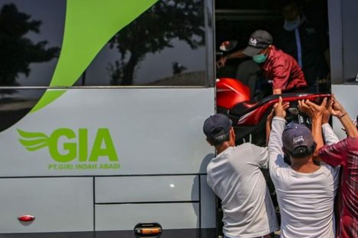 Petugas bus menaikkan motor ke dalam bus di Terminal Kalideres, Jakarta, Rabu (22/4).