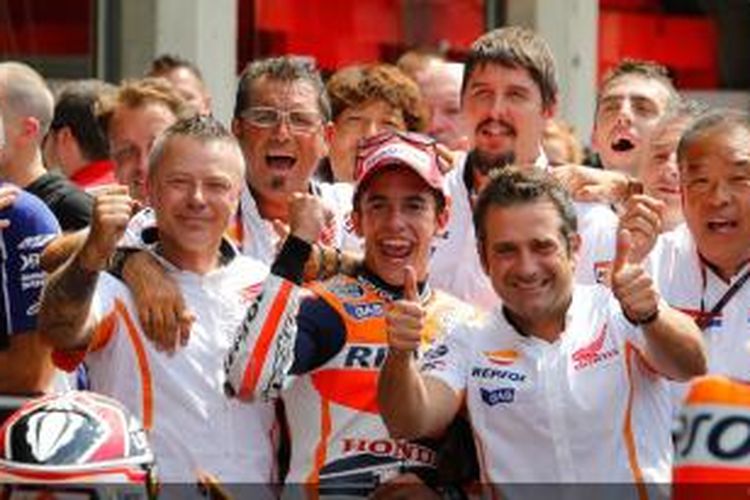 Pebalap Repsol Honda, Marc Marquez (tengah), mengepalkan tangan dan berpose bersama kru Honda usai kemenangannya pada balapan GP Indianapolis, di Sirkuit Indianapolis Motor Speedway, Minggu (18/8/2013).