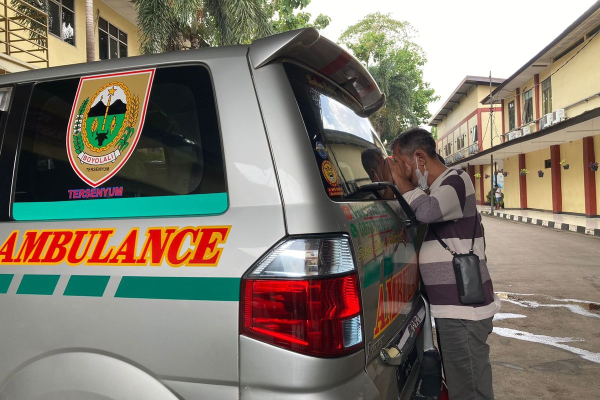 Heri, suami dari salah satu korban pembunuhan di Bekasi Utara berinisial Y, sedang mengintip mobil jenazah yang mengangkut mayat istrinya di RS Polri Kramat Jati, Jakarta Timur, Selasa (28/2/2023).