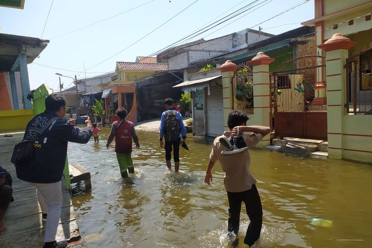 Saat pelajar yang tinggal di Tambak Lorok, Kota Semarang, Jawa Tengah menerjang banjir rob