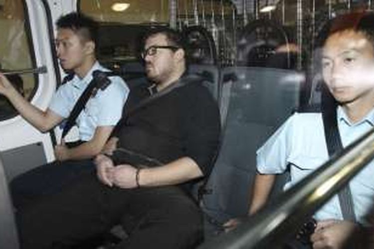 Rurik George Caton Jutting (tengah) dikawal polisi dalam kendaraan menuju pengadilan di Hongkong, 2014.

