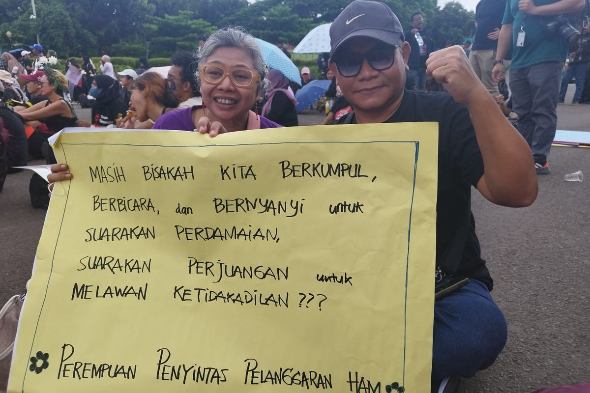 Pasutri Nancy Sunarno (50) dan Pius Wisnugraha Trias (54) saat berpartisipasi dalam aksi Perempuan Indonesia Geruduk Istana di Silang Monas Barat Daya, Gambir, Jakarta Pusat, Jumat (8/3/2024).