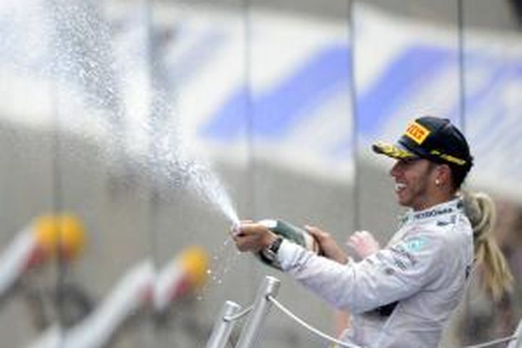 Pebalap Mercedes asal Inggris, Lewis Hamilton merayakan kemenangannya pada GP Spanyol di atas podium Sirkuit Catalunya, Minggu (11/5/2014).