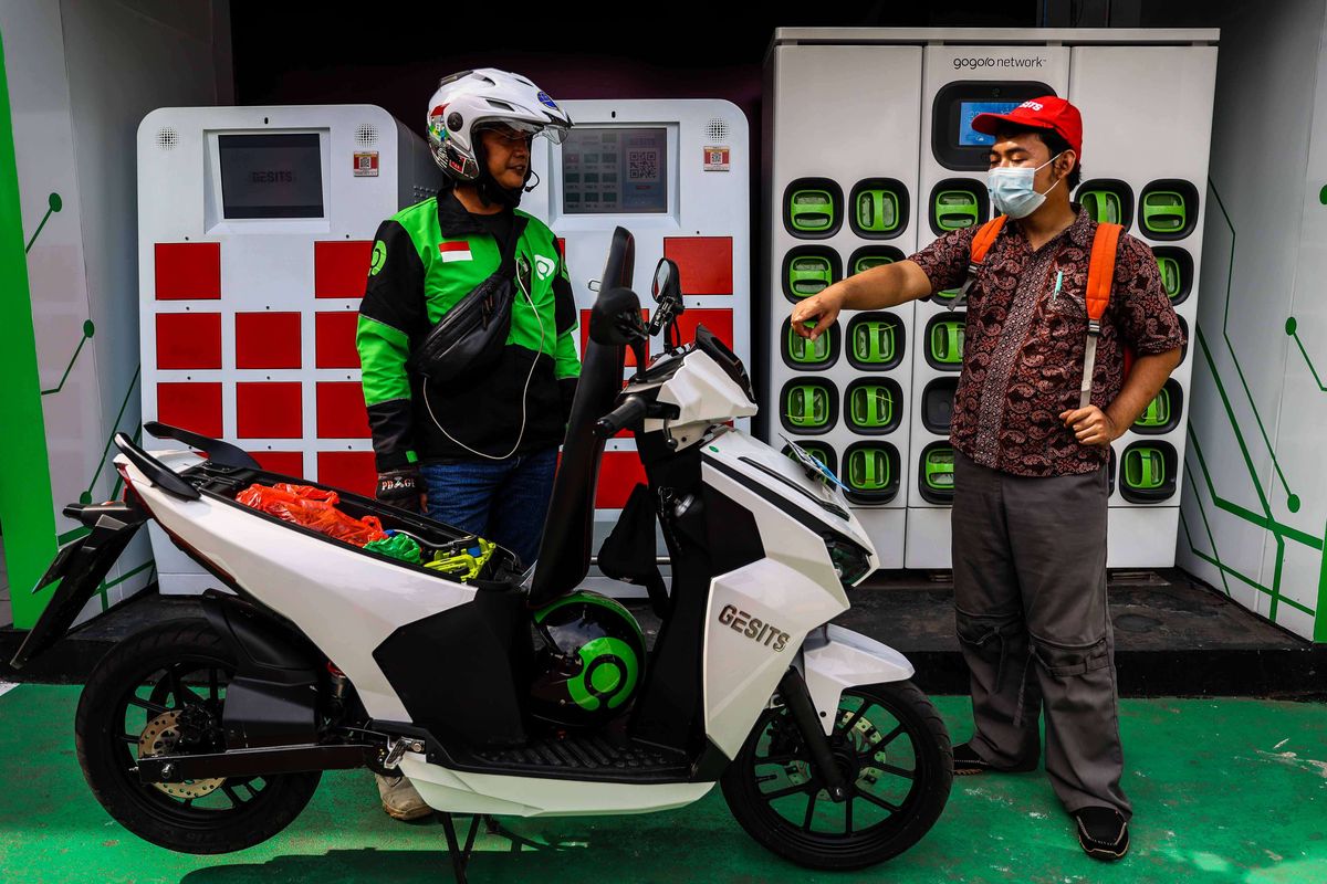 Pengemudi ojek daring mengganti baterai sepeda motor listrik dengan yang sudah penuh terisi di Stasiun Penukaran Baterai Kendaraan Listrik Umum (SPBKLU) di SPBU Pertamina, Jalan MT Haryono, Jakarta, Senin (28/3/2022). Pemerintah Indonesia menargetkan dua juta kendaraan listrik dapat digunakan oleh masyarakat Indonesia pada 2025 sebagai salah satu upaya untuk menerapkan penggunaan energi terbarukan.