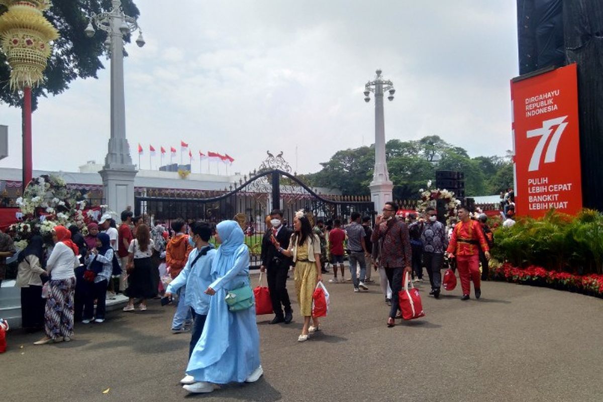 Sejumlah warga berfoto dengan latar belakang Istana Negara usai pelaksanaan upacara HUT ke-77 Republik Indonesia, Rabu (17/8/2022).