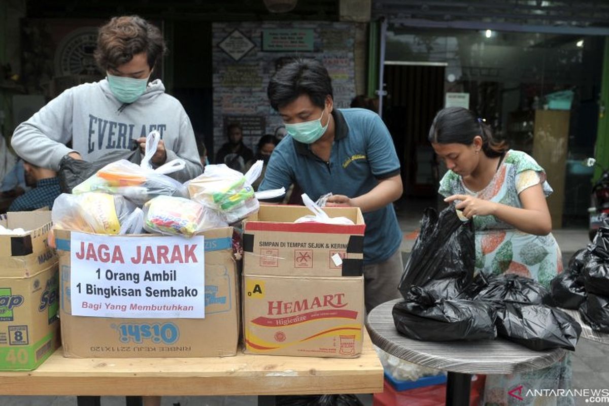 Warga menyiapkan paket sembako yang akan dibagikan kepada warga lainnya yang membutuhkan. (Antara/Fikri Yusuf)