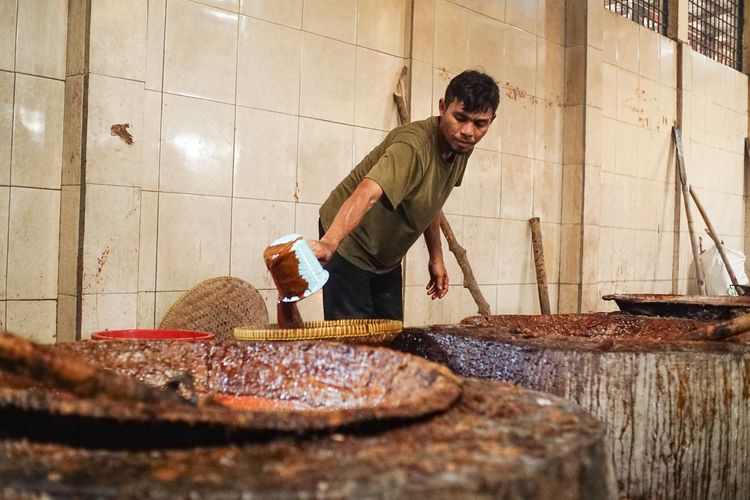 A number of workers filter the dodol and basket cake dough at the Ny Dodol and Cake production house. Lauw (LKW), in Tangerang, Banten, Friday (17/1/2025). The production process uses a traditional furnace.