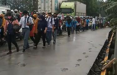 Foto yang menampilkan pejalan kaki melintasi ruas jalan yang baru dicor di Kabupaten Tangerang viral di media sosial.