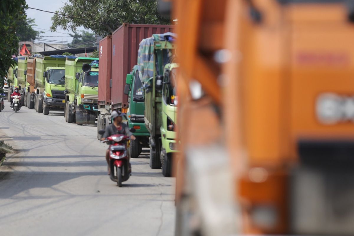 Ratusan mobil truk berhenti menunggu selesainya pembatasan jam operasional truk di jalan raya Parung Panjang menuju Legok, Kabupaten Tangerang, Banten, Kamis (10/01/2019). Pemerintah Kabupaten Tangerang membatasi jam operasional kendaraan jenis truk golongan 2 hingga truk golongan 5 yang membawa muatan material tanah dan pasir. Jenis-jenis kendaraan tersebut baru dapat melintas pukul 22.00-05.00 WIB.