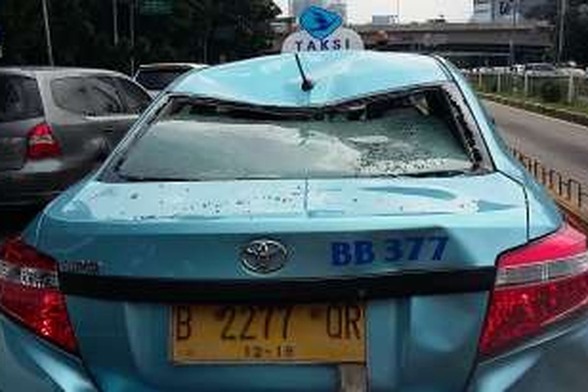 Taksi Blue Bird dirusak oleh pengunjuk rasa di Jalan Jenderal Gatot Subroto, Jakarta, Selasa (22/3/2016).