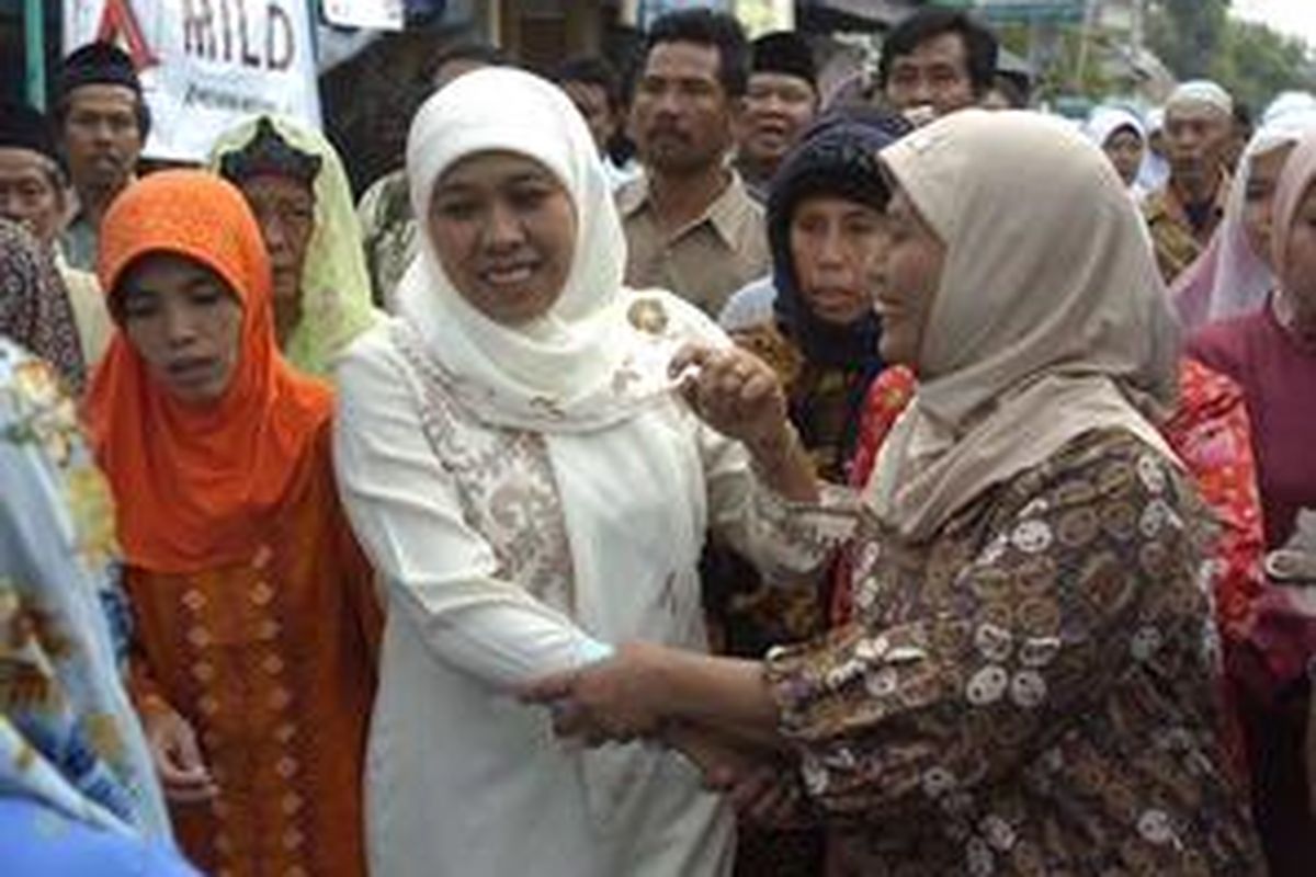Khofifah Indar Parawansa, calon gubernur Jatim dengan nomor urut satu disambut pendukungnya saat akan memberikan suaranya di TPS 24 Jemur Wonosari, Surabaya, Rabu (23/7).