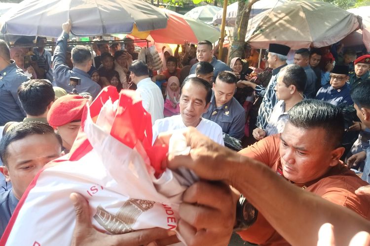 Warga berebut saat Presiden Joko Widodo membagikan kaos dan sembako di pasar Grogolan, Pekalongan Kota