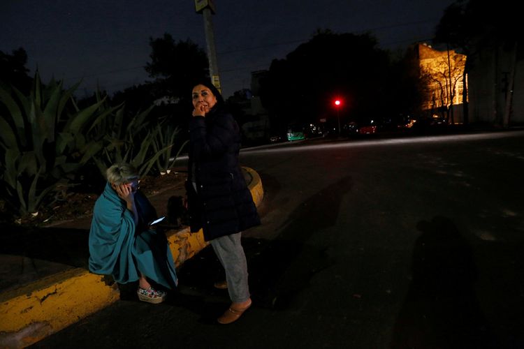 Warga Mexico City, Meksiko yang berkumpul di pinggiran jalan setelah merasakan guncangan gempa pada Kamis tengah malam waktu setempat.