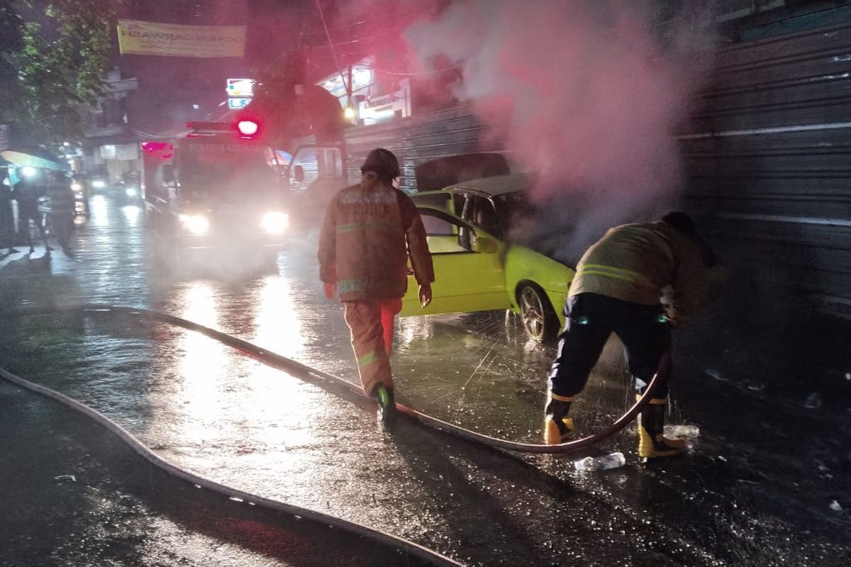 Petugas Damkar saat berupaya memadamkan api yang membakar mobil sedan di sekitaran KBD, Kecamatan Driyorejo, Gresik, Jawa Timur, Jumat (5/12/2025).