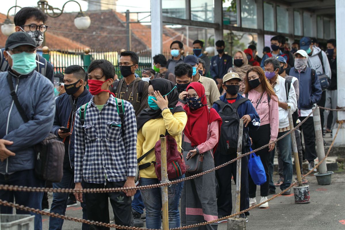 Warga antre menggunakan KRL Commuter Line di Stasiun Bogor, Senin (15/6/2020). Dinas Tenaga Kerja, Transmigrasi, dan Energi (Disnakertransgi) DKI Jakarta mengatur ketentuan waktu masuk, pulang, dan istirahat kantor bagi pekerja atau karyawan di Ibu Kota selama masa transisi pembatasan sosial berskala besar (PSBB).