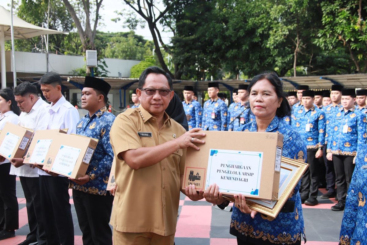 Mendagri Tito menyerahkan penghargaan berupa laptop kepada 15 pegawai yang telah berjasa dalam menjalankan tugas di bidang pengarsipan.