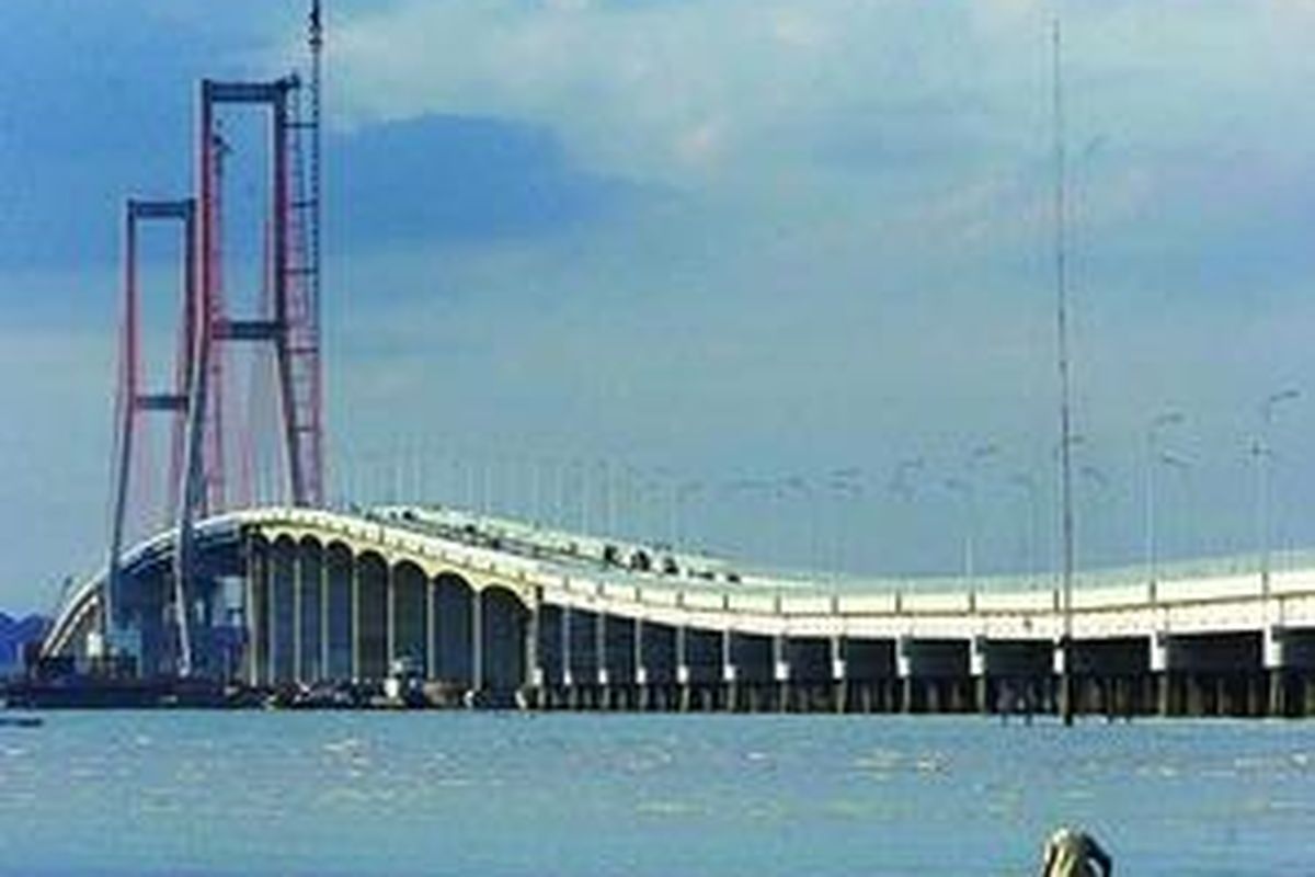 Warga menyusuri Selat Madura saat air surut untuk mengumpulkan kerang di sekitar proyek Jembatan Surabaya-Madura (Suramadu) di kawasan Tambak Wedi, Surabaya, Jawa Timur. Jembatan Suramadu yang menghabiskan dana sebesar Rp 4,5 triliun itu telah siap dioperasikan dengan membawa harapan baru terjadinya percepatan pembangunan di kawasan Madura.