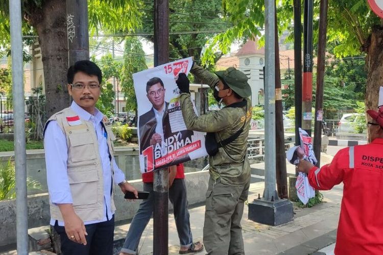 Petugas gabungan sedang melakukan pencopotan alat peraga kampanye di Jalan Protokol Kota Semarang, Jawa Tengah. 