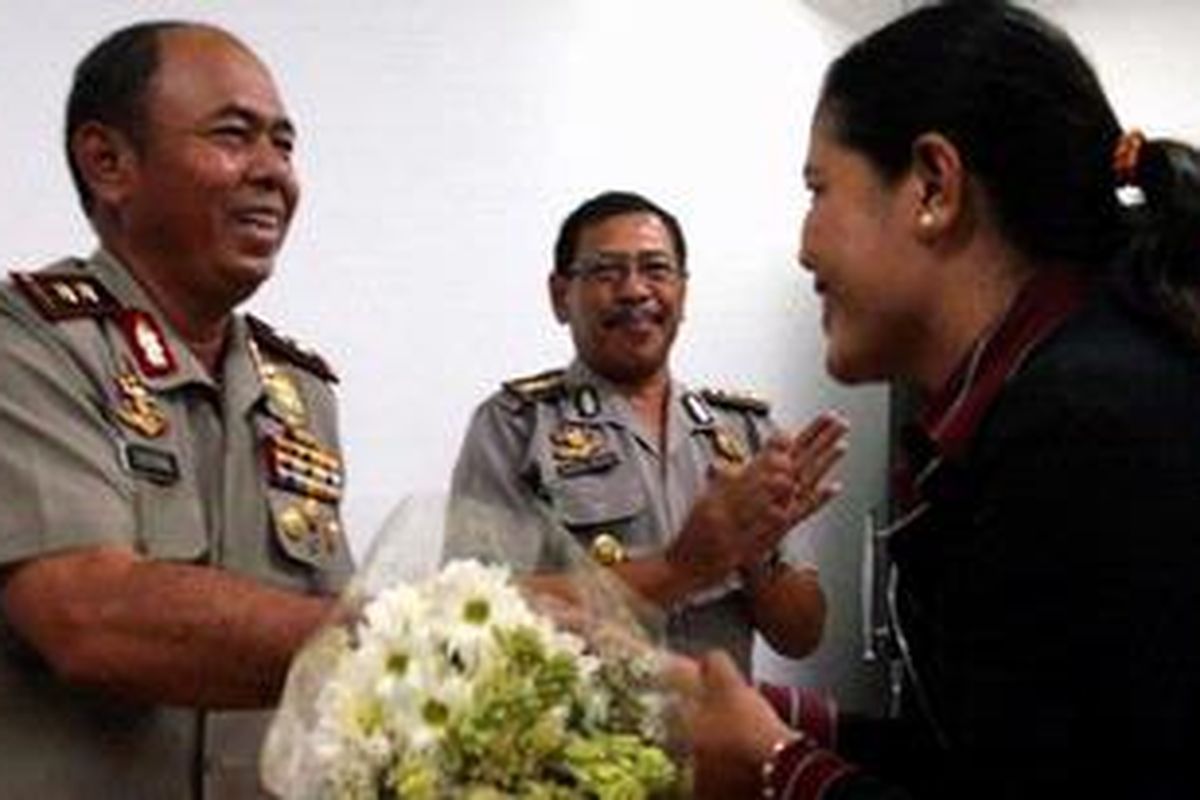 Kepala Kepolisian Daerah Bali Irjen Sutisna menerima bunga dari Ketua Komisi Perlindungan Anak Indonesia (KPAI) Bali Sri Wahyuni di Mapolda Bali, Senin (17/4/2010). Bunga itu merupakan penghargaan atas kerja keras polisi hingga berhasil menangkap pelaku perkosaan berantai di Bali dan Batam.