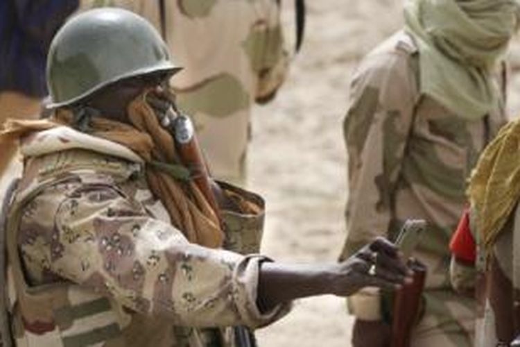 Seorang prajurit angkatan darat Niger sambil menutup hidung merekam lokasi ditemukannya puluhan mayat korban Boko Haram di kota Damasak, Nigeria.