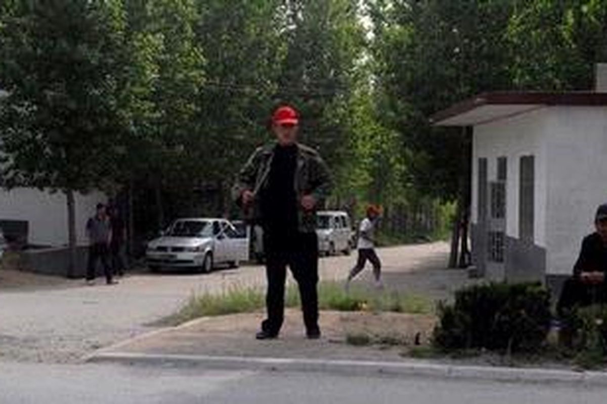 Sejumlah polisi berpakaian preman memonitor jalan masuk ke Desa Dongshigu, tempat aktivis Chen Guangcheng tinggal. Melalui perjuangan berat, Chen yang seorang tunanetra berhasil melarikan diri dari rumahnya yang dijaga ketat polisi dan aparat pemerintah setempat.