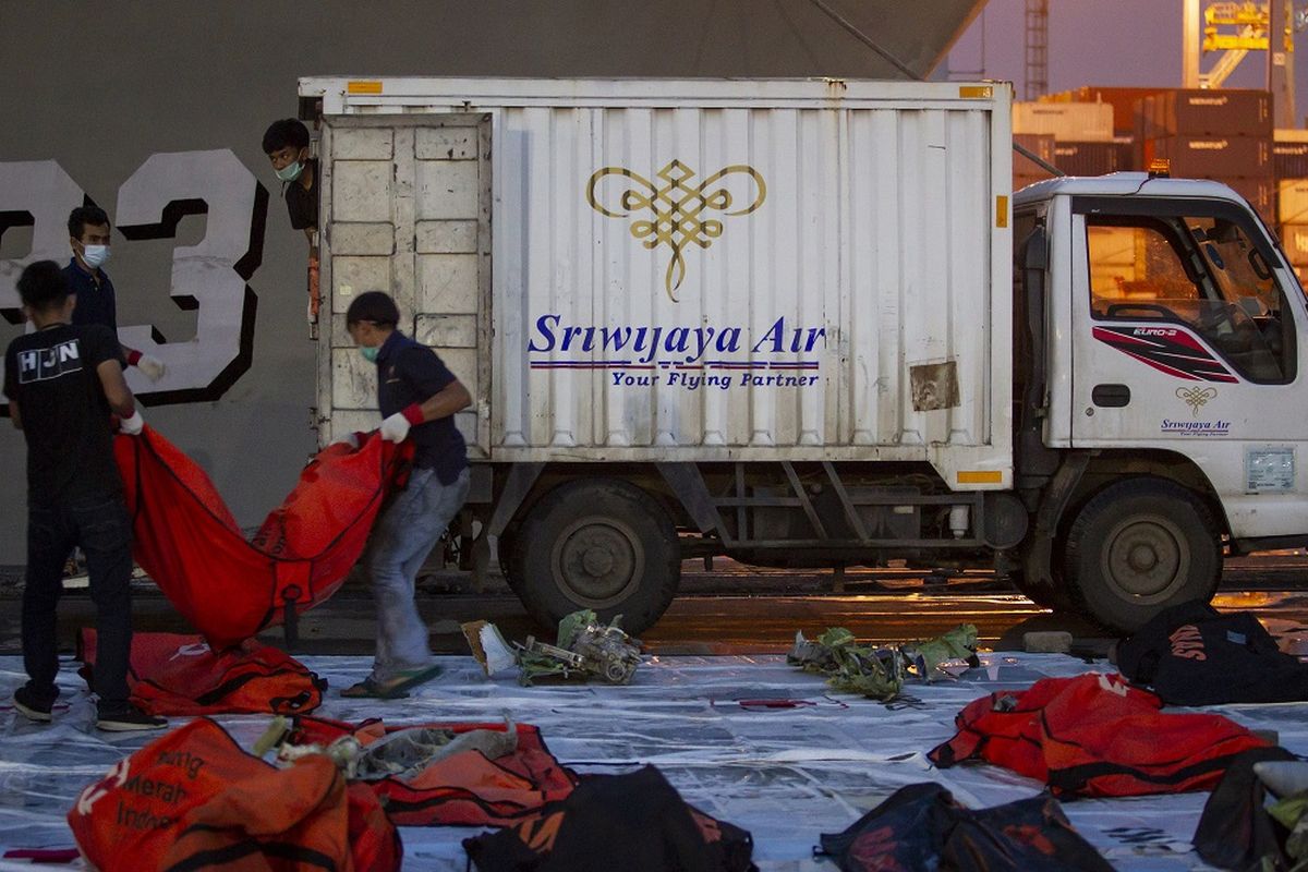 Petugas mengangkat bagian pesawat Sriwijaya Air SJ-182 ke dalam mobil di Dermaga JICT II, Pelabuhan Tanjung Priok, Jakarta Utara, Kamis (21/1/2021). Tim SAR gabungan menyerahkan barang-barang temuan dari jatuhnya pesawat Sriwijaya Air SJ-182 kepada Komite Nasional Keselamatan Transportasi (KNKT) untuk dilakukan investigasi lebih lanjut. ANTARA FOTO/Dhemas Reviyanto/foc.