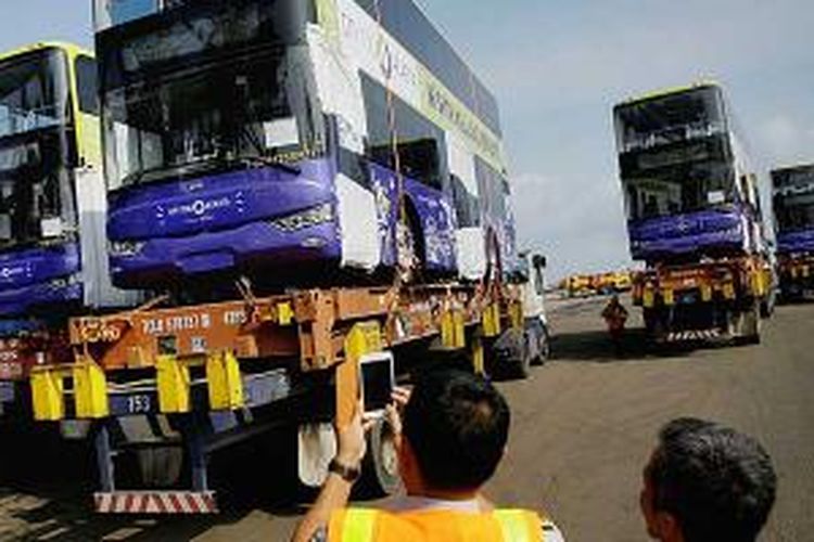 Bus tingkat diturunkan dari kapal pengangkut di Terminal 1 Jakarta International Container Terminal, Tanjung Priok, Jakarta Utara, Selasa (14/1/2014). Lima bus tingkat tersebut akan digunakan untuk mendukung kegiatan pariwisata Ibu Kota.