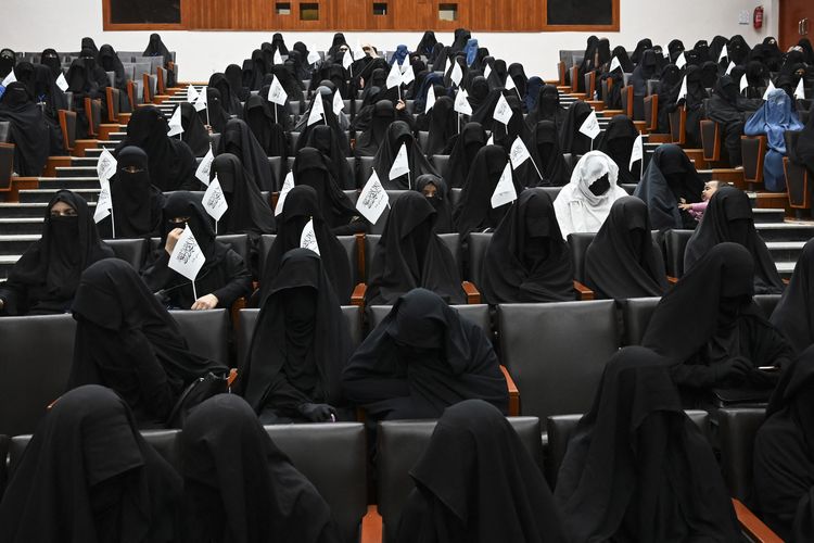 Para mahasiswa bercadar memegang bendera Taliban saat mereka mendengarkan pembicara sebelum unjuk rasa pro-Taliban di Universitas Pendidikan Shaheed Rabbani di Kabul pada Sabtu (11/9/2021). [AAMIR QURESHI/AFP]