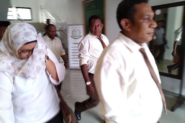RU (tutup muka), salah satu dari tiga tersangka kasus Korupsi KPU Sarmi, sedang digiring penyidik Kejati Papua ke dalam mobil tahanan (22/07/2019)