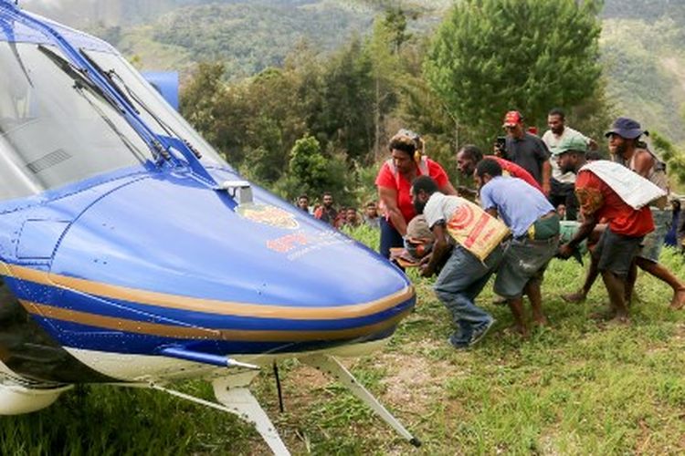 Foto selebaran ini diambil dan diterima dari Manolos Aviation pada 11 September 2022, menunjukkan seorang penduduk desa yang terluka di atas tandu dievakuasi dengan helikopter dari desa Kombul ke kota terdekat Lae setelah gempa berkekuatan 7,6 yang melanda pantai Papua Nugini.