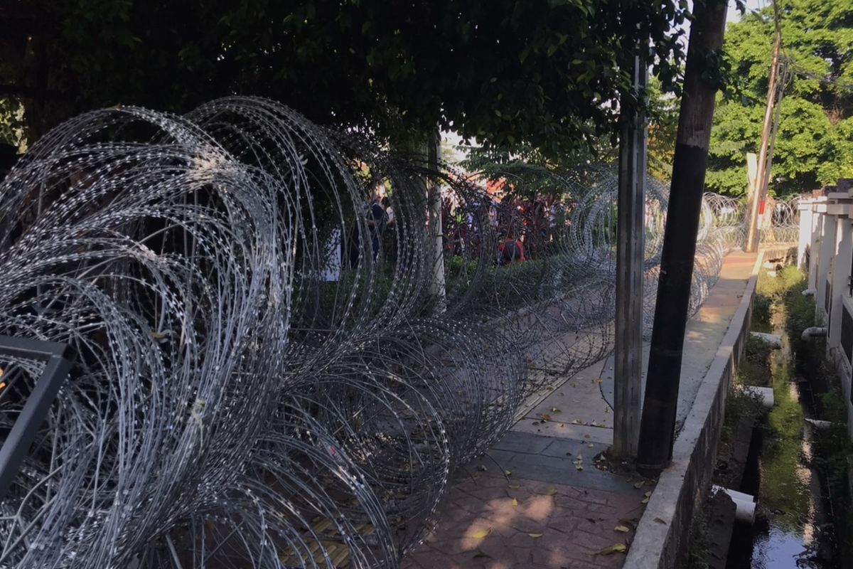 Polisi memasang kawat berduri di sepanjang trotoar Gedung Pengadilan Negeri Jakarta Timur, Cakung, Jakarta Timur pada Jumat (26/3/2021) pagi.