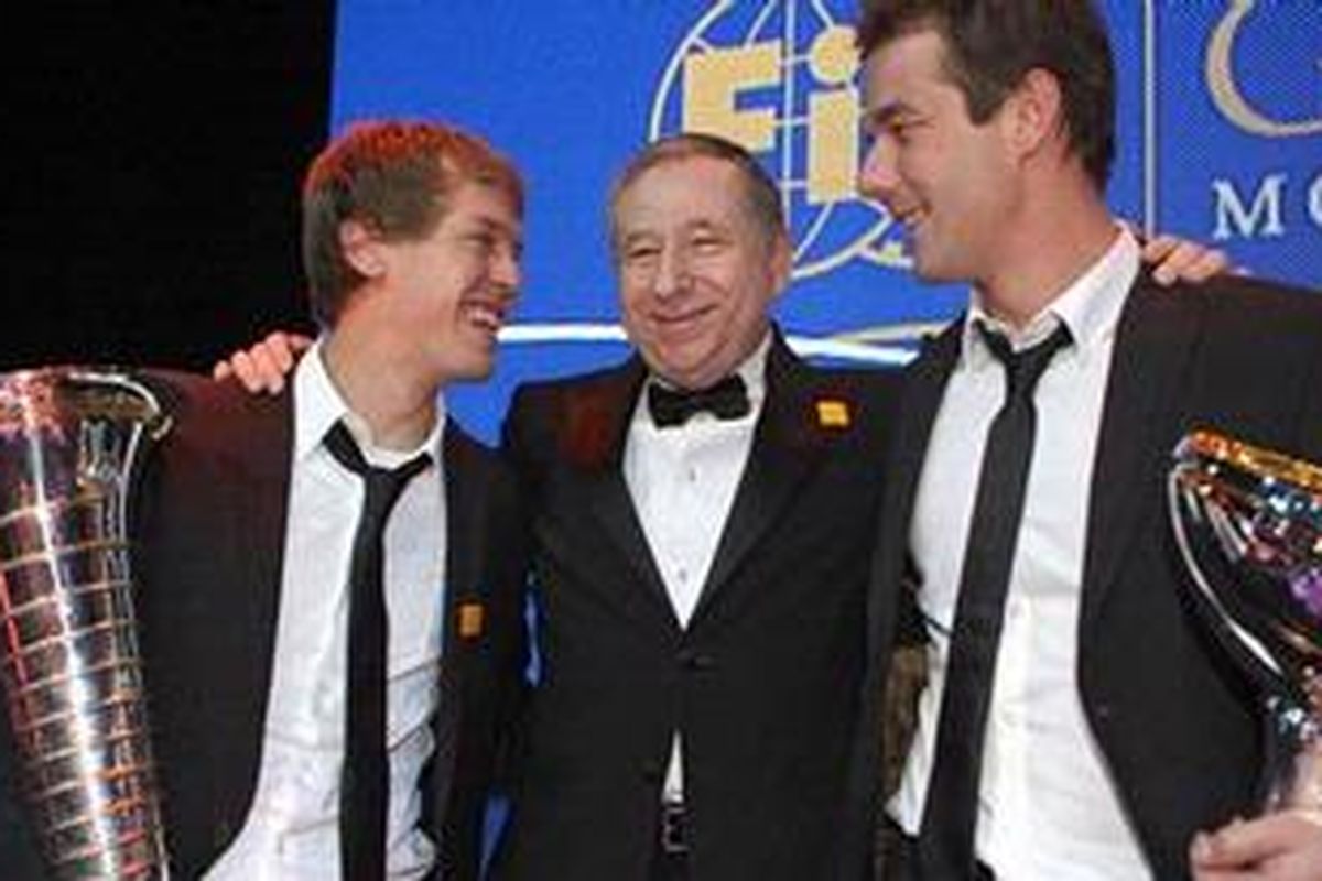 Pebalap Red Bull Racing, Sebastian Vettel (kiri) dan pereli Sebastien Loeb (kanan) mengapiti Presiden FIA Jean Todt. Vettel dan Loeb secara resmi dinobatkan sebagai juara dunia F1 dan reli, setelah mendapatkan trofi tersebut di Monaco, Jumat (10/12/10).