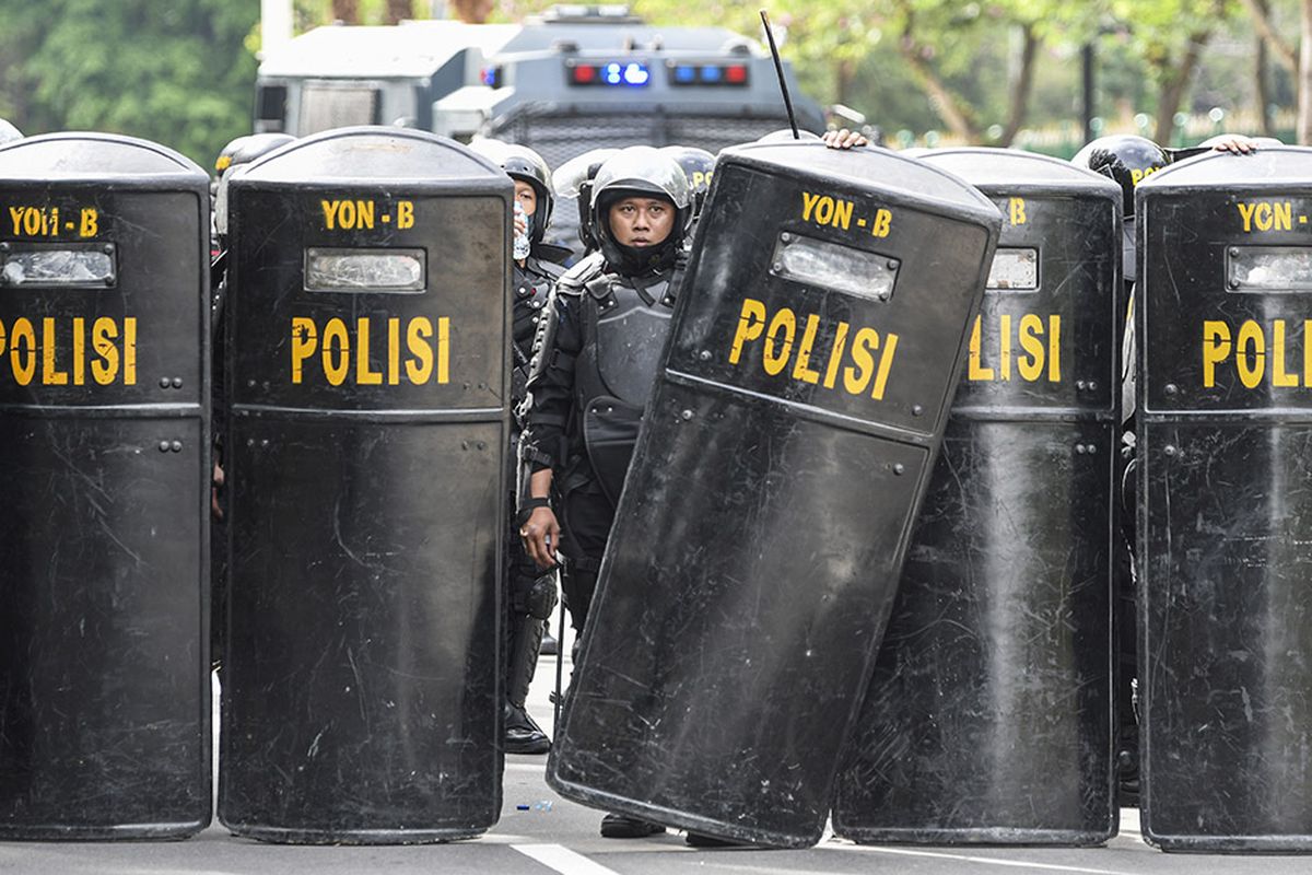 Sejumlah personel Polisi membentuk barikade saat membubarkan massa aksi demonstrasi 1812, di kawasan Medan Merdeka Selatan, Jakarta, Jumat (18/12/2020). Kepolisian membubarkan paksa massa aksi demonstrasi dikarenakan angka penyebaran Covid-19 masih tinggi di wilayah Jakarta.