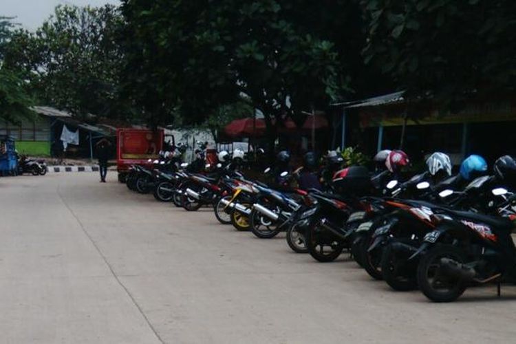 Deretan parkir liar motor yang berada di bahu jalan samping jalur hijau atau di dekat Hutan Kota di Kawasan Industri Pulogadung, Jakarta Timur. Selasa (5/1/2016)