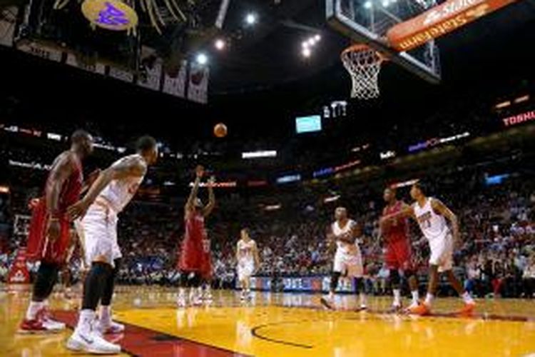 Pebasket Miami Heat, LeBron James (tengah) melakukan tembakan bebas saat timnya melawan Phoenix Suns di American Airlines Arena, Senin (25/11/2013).