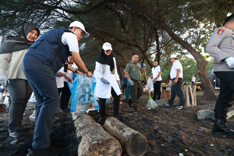 Bupati Banyuwangi Ipuk Fiestiandani bersih-bersih Pantai Grand Watu Dodol saat peluncuran Gerakan Wisata Bersih (GWB) Kementerian Pariwisata RI, Selasa (17/6/2025). 