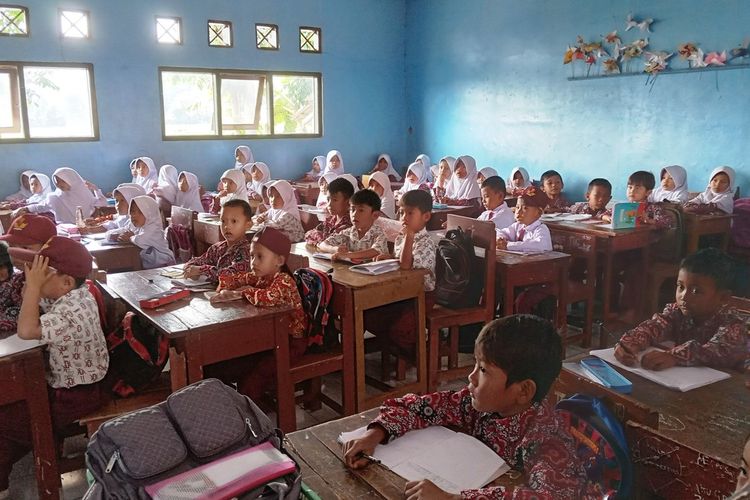 Murid sekolah dasar di Kabupaten Cianjur, Jawa Barat, ini terpaksa duduk berdempetan dan penuh sesak karena ruang kelas mereka ada yang rusak terdampak bencana.