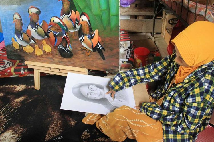 Rohani Yusuf (41), pelukis disabiliitas sedang melukis di rumahnya Desa Pulo, Kecamatan Syamtalira Aron, Kabupaten Aceh Utara, Provinsi Aceh, Rabu (26/10/2022).