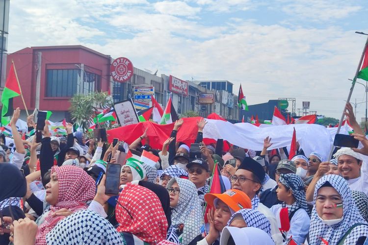 Warga Depok mengikuti aksi damai bela Palestina di kawasan Grand Depok City, Minggu (26/11/2023) pagi.