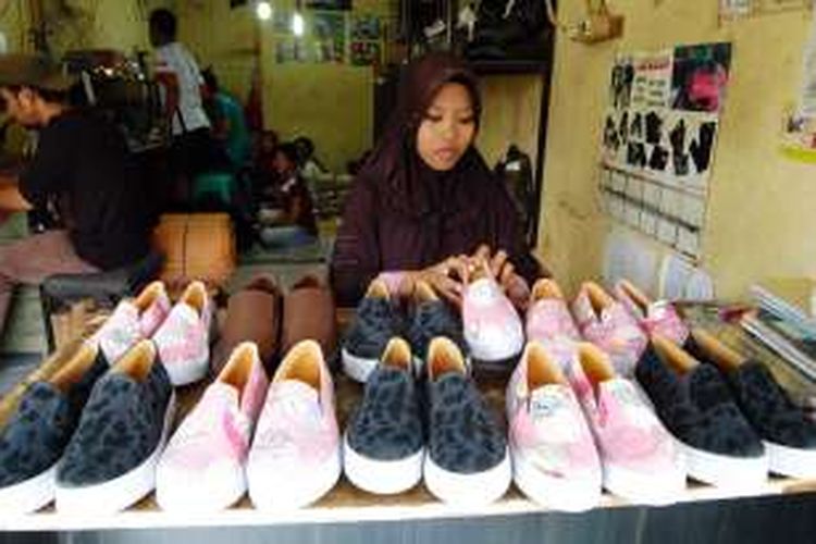Seorang perajin sepatu dan sandal di Kecamatan Ciomas, Kabupaten Bogor sedang merapikan sepatu-sepatu yang siap dijual ke toko grosir, Senin (15/2/2016). Di tengah ancaman persaingan bisnis dengan produk dan merk terkenal, para perajin sepatu dan sandal di wilayah Ciomas tetap setia menjalani profesinya.