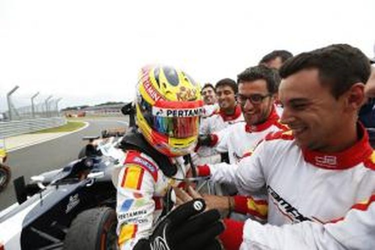 Pebalap Campos Racing asal Indonesia, Rio Haryanto (kiri), merayakan bersama tim atas kemenangannya pada srpint race GP2 Inggris di Sirkuit Silverstone, Minggu (5/7/2015).