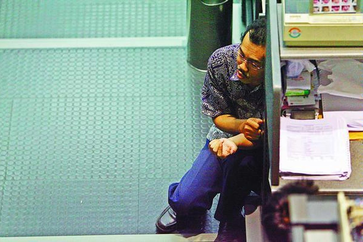 Seorang pialang terduduk lesu seusai penutupan perdagangan saham di Bursa Efek Indonesia, Jakarta.