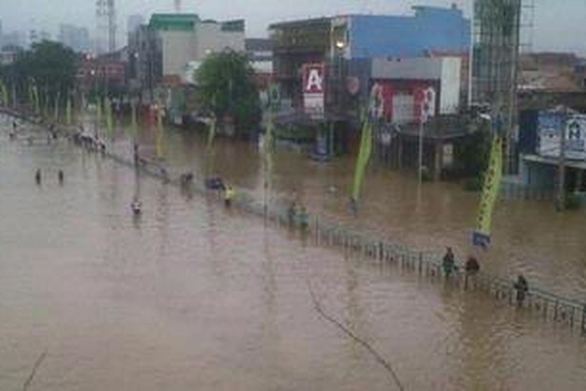 Luapan Sungai Ciliwung menggenangi Jalan KH Abdullah Syafei, Tebet, Jakarta Selatan, Rabu (16/1/2013). Jalan itu akhirnya ditutup. Pengendara dari arah timur dialihkan ke Jalan DI Panjaitan-Cawang, sedangkan dari arah Casablanca dialihkan ke Jalan Saharjo-Manggarai.