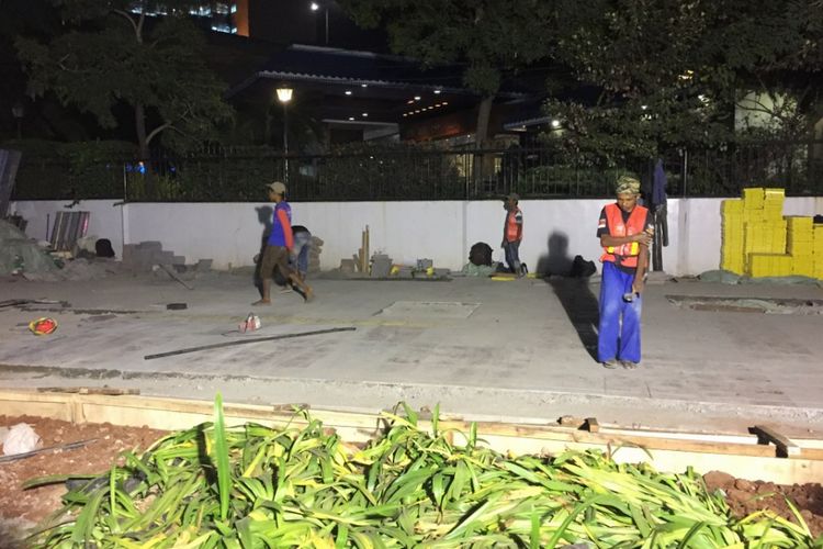 Sejumlah pekerja membersihkan trotoar di depan Hotel Le Meridien, Karet Tengsin, Jakarta Pusat, Jumat (6/7/2018) malam. Jalur pedestrian di sepanjang koridor ini kini tengah direvitalisasi dalam rangka menyambut Asian Games 2018.