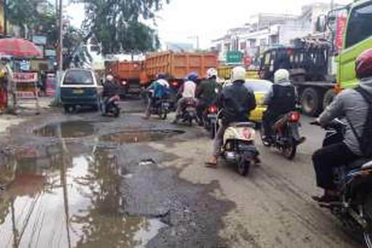 Jalan Medan-Binjai, tepatnya di Kampung Lalang Medan, penuh lubang dan truk-truk besar, Senin (17/10/2016)